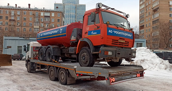 Перевозка грузовика KAMAZ с цистерной на платформе зимой